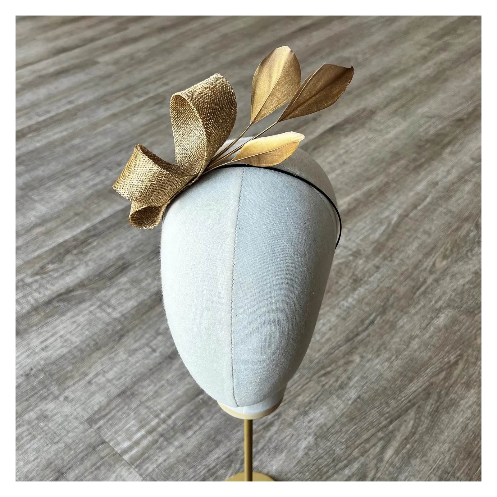 Delikatny fascynator na opasce w złotym kolorze.