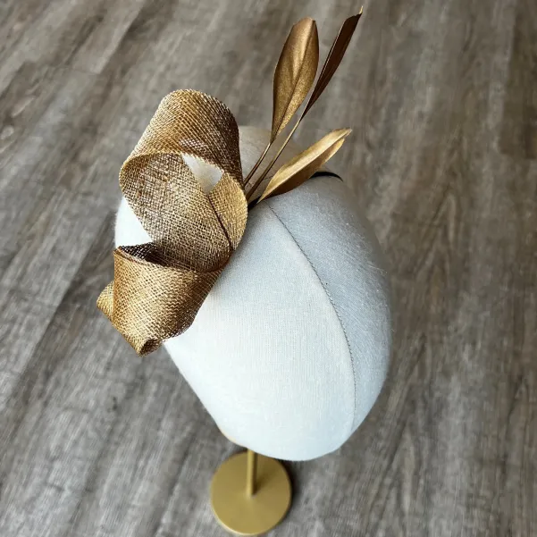 Delikatny fascynator na opasce w złotym kolorze. Delikatny fascynator na opasce w złotym kolorze.