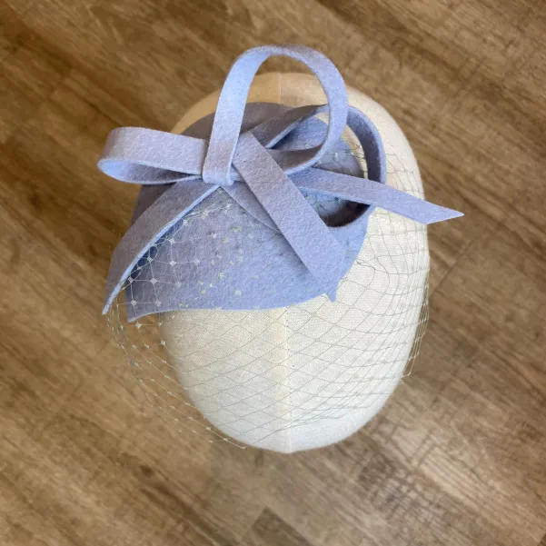 Niebieski filcowy stroik do włosów z niewielką woalką.