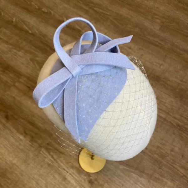 Niebieski filcowy stroik do włosów z niewielką woalką.