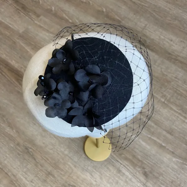 Czarny toczek zdobiony ręcznie formowanymi jedwabnymi kwiatami.