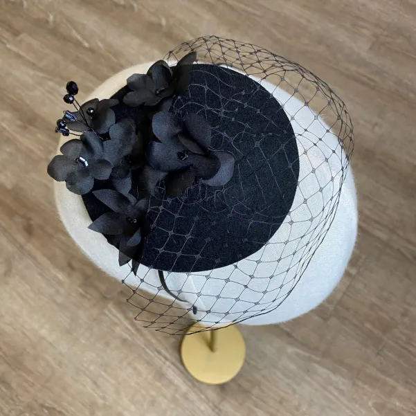 Czarny toczek zdobiony ręcznie formowanymi jedwabnymi kwiatami.