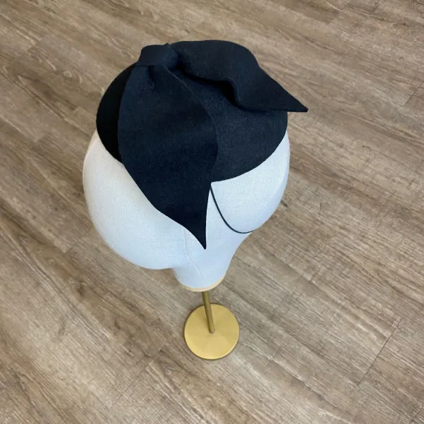 Czarne eleganckie nakrycie głowy kokardą.