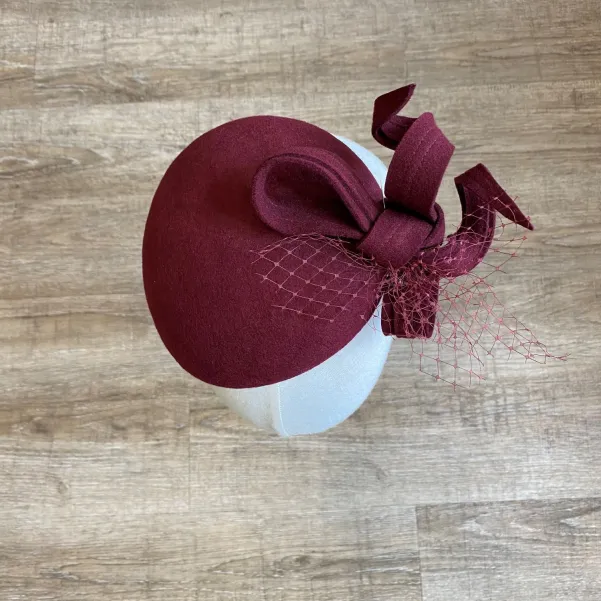 Ozdobne nakrycie głowy- mały burgundowy kapelusz.