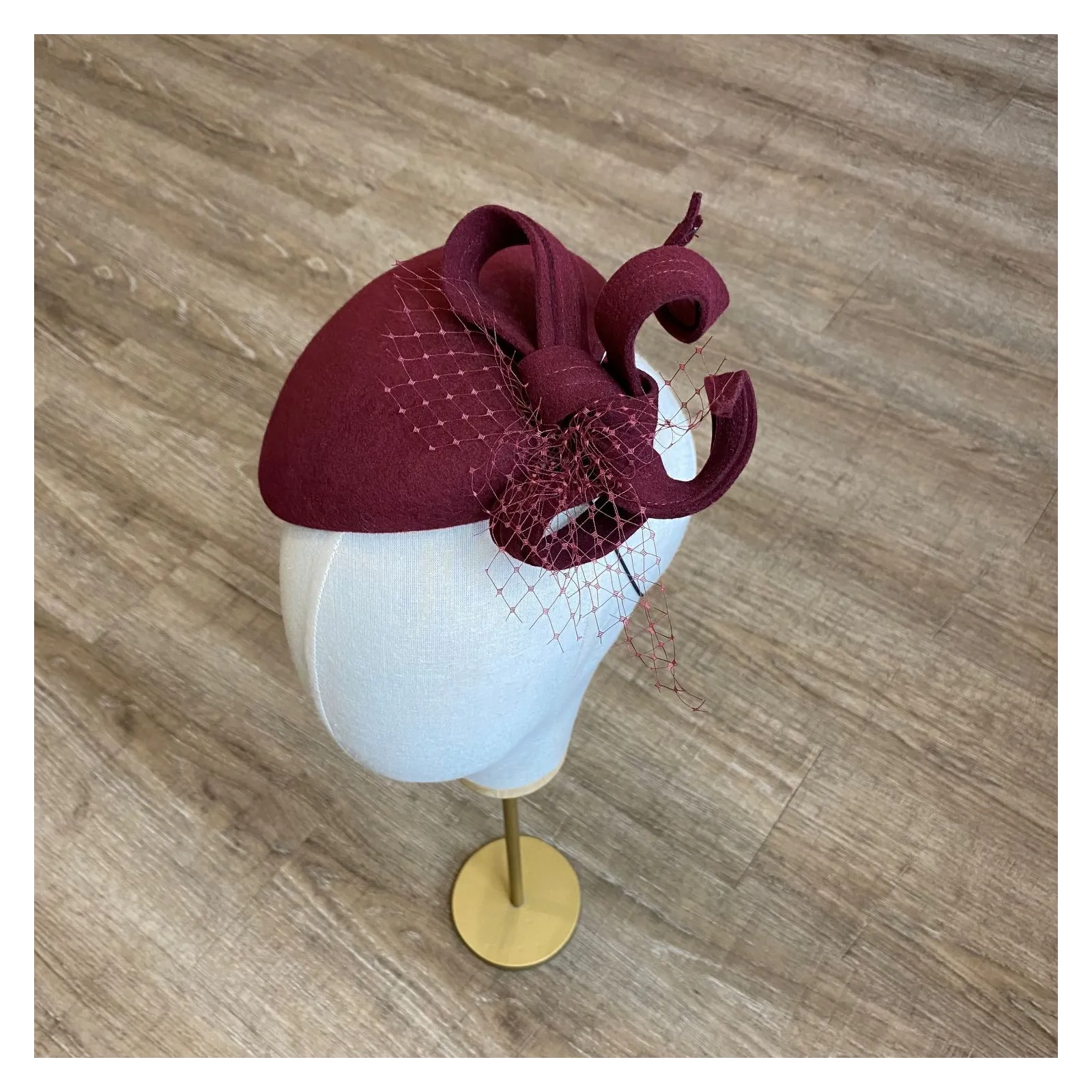 Ozdobne nakrycie głowy- mały burgundowy kapelusz.