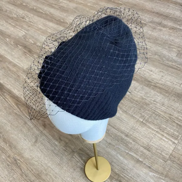 Kaszmirowa czapka z tiulem i aksamitną aplikacją.