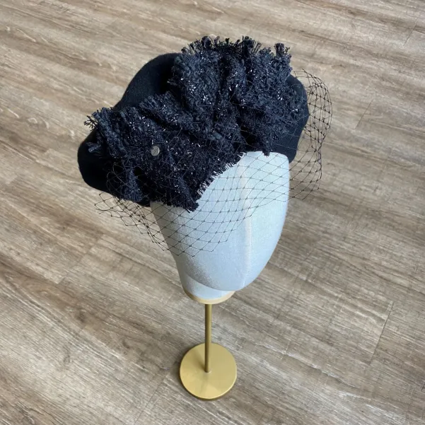 Czarny beret damski z woalką i ozdobą z tweedu.