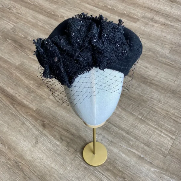 Czarny beret damski z woalką i ozdobą z tweedu.