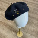Gwiezdny beret damski z biżuteryjnym zdobieniem.