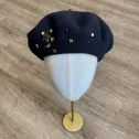 Gwiezdny beret damski z biżuteryjnym zdobieniem.