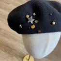 Gwiezdny beret damski z biżuteryjnym zdobieniem.