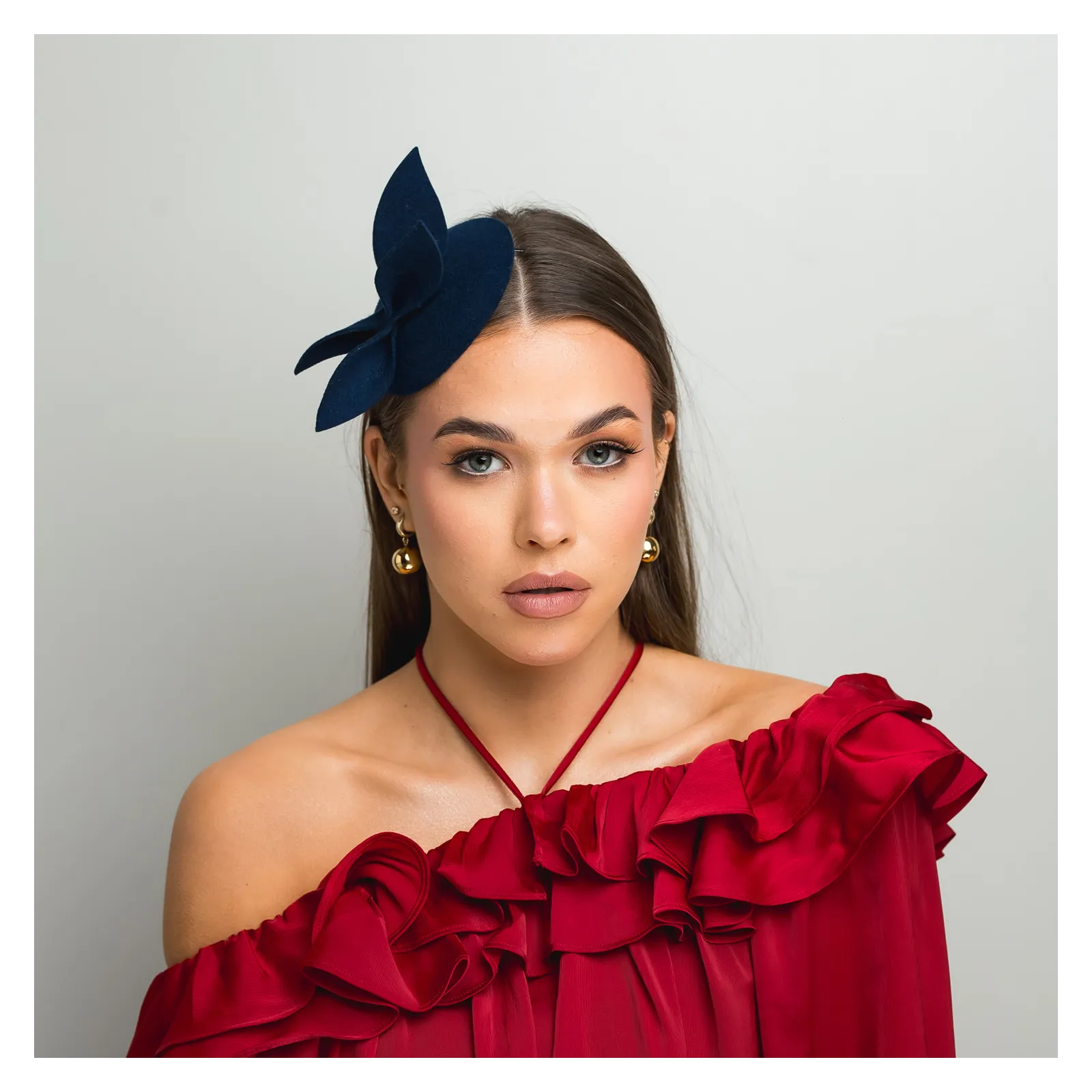 Granatowy mini kapelusik z gustowną ozdobą.