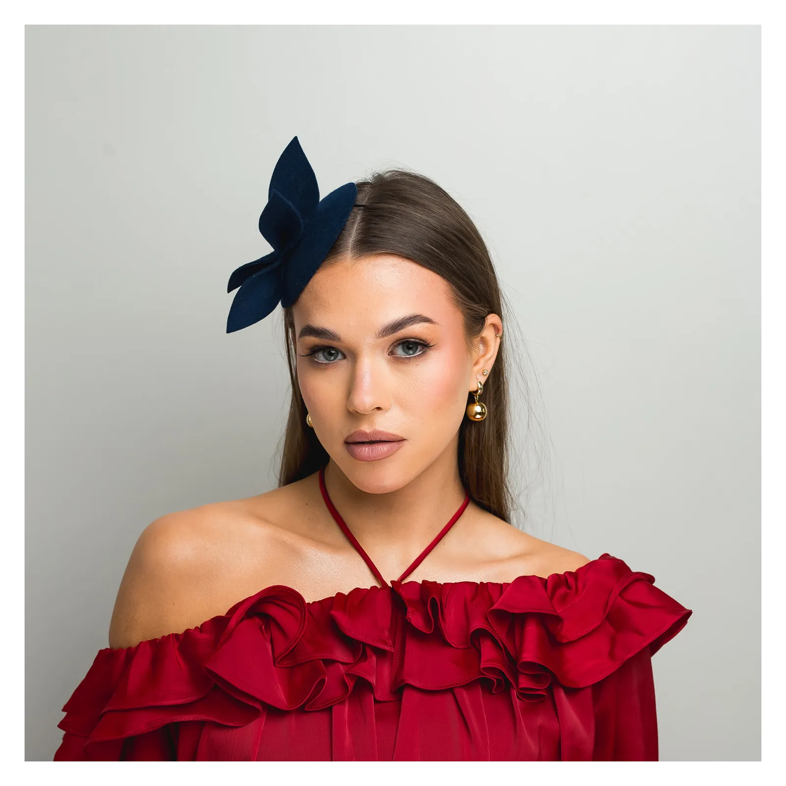 Granatowy mini kapelusik z gustowną ozdobą.