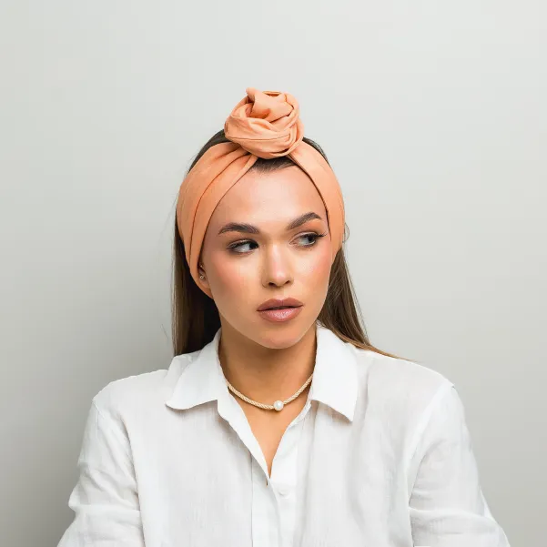 Lniana opaska twistband w kolorze brzoskwiniowym.