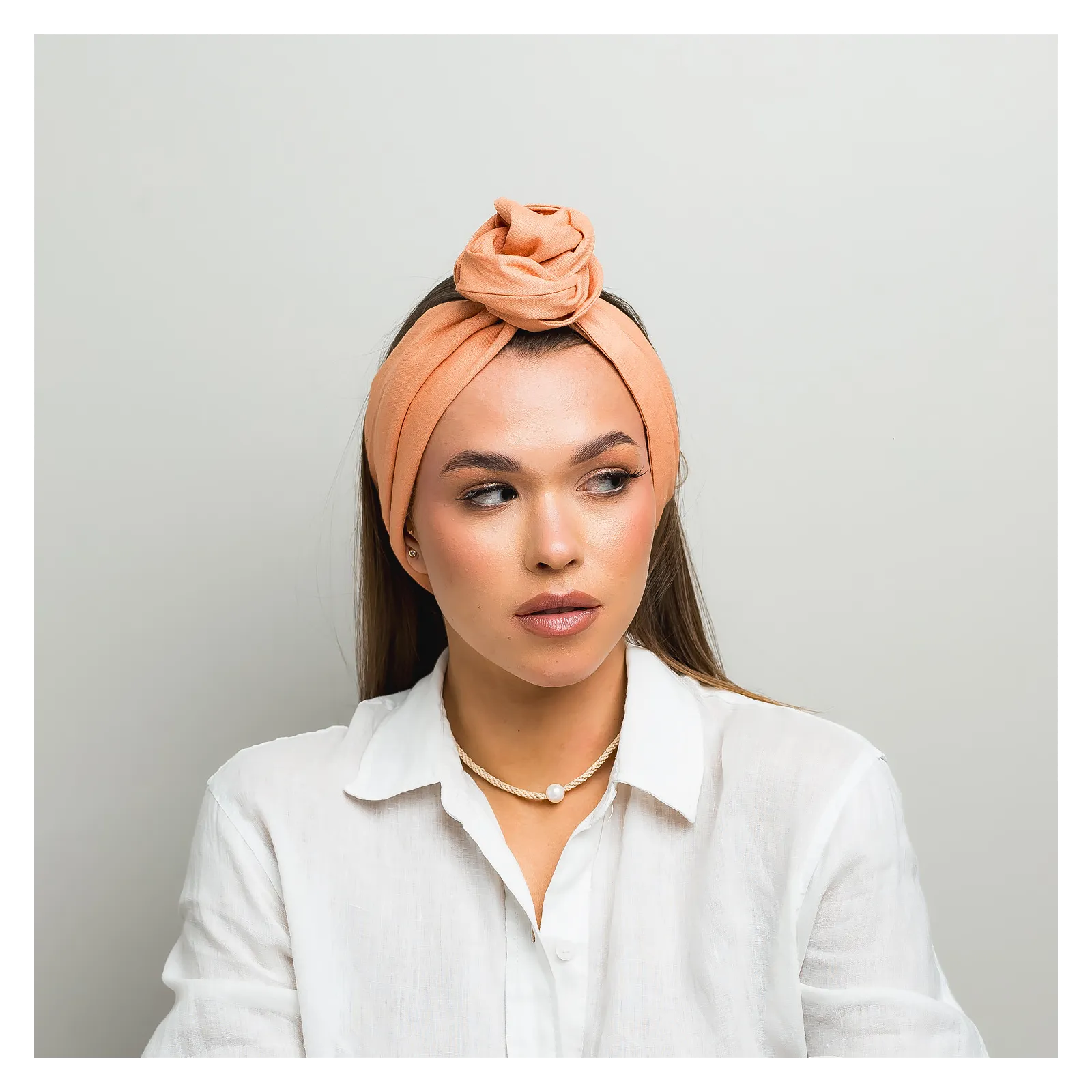 Lniana opaska twistband w kolorze brzoskwiniowym.