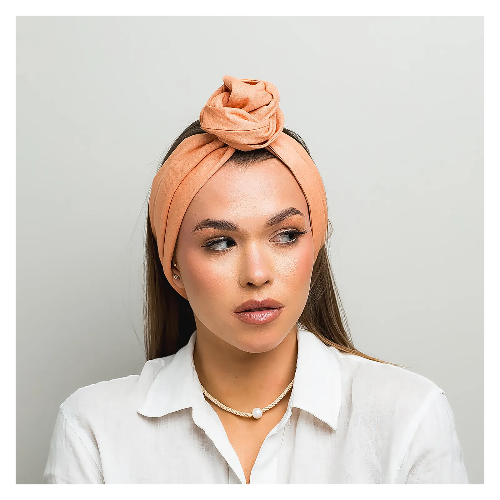 Lniana opaska twistband w kolorze brzoskwiniowym.