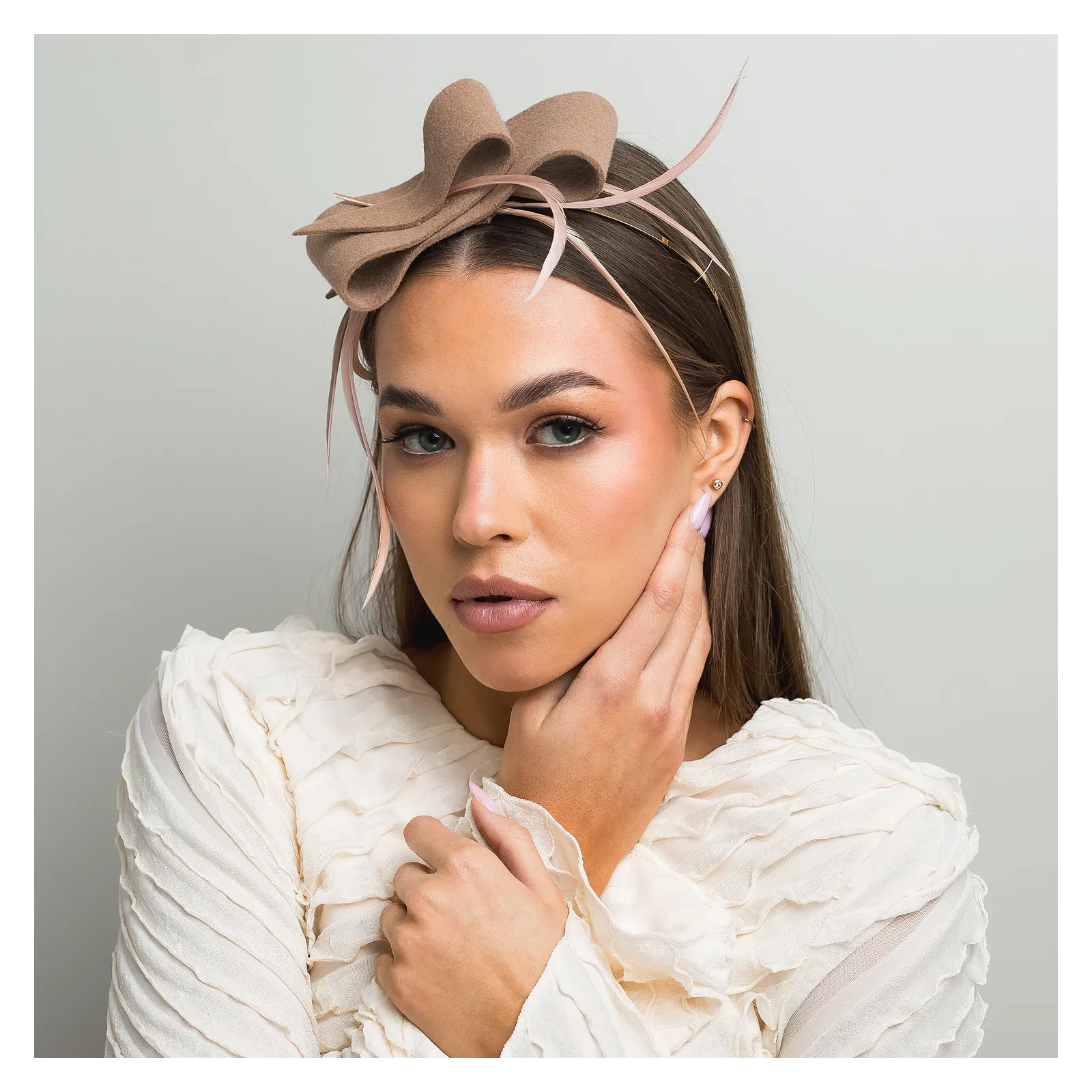 Beżowa ozdoba do włosów z piórkami.