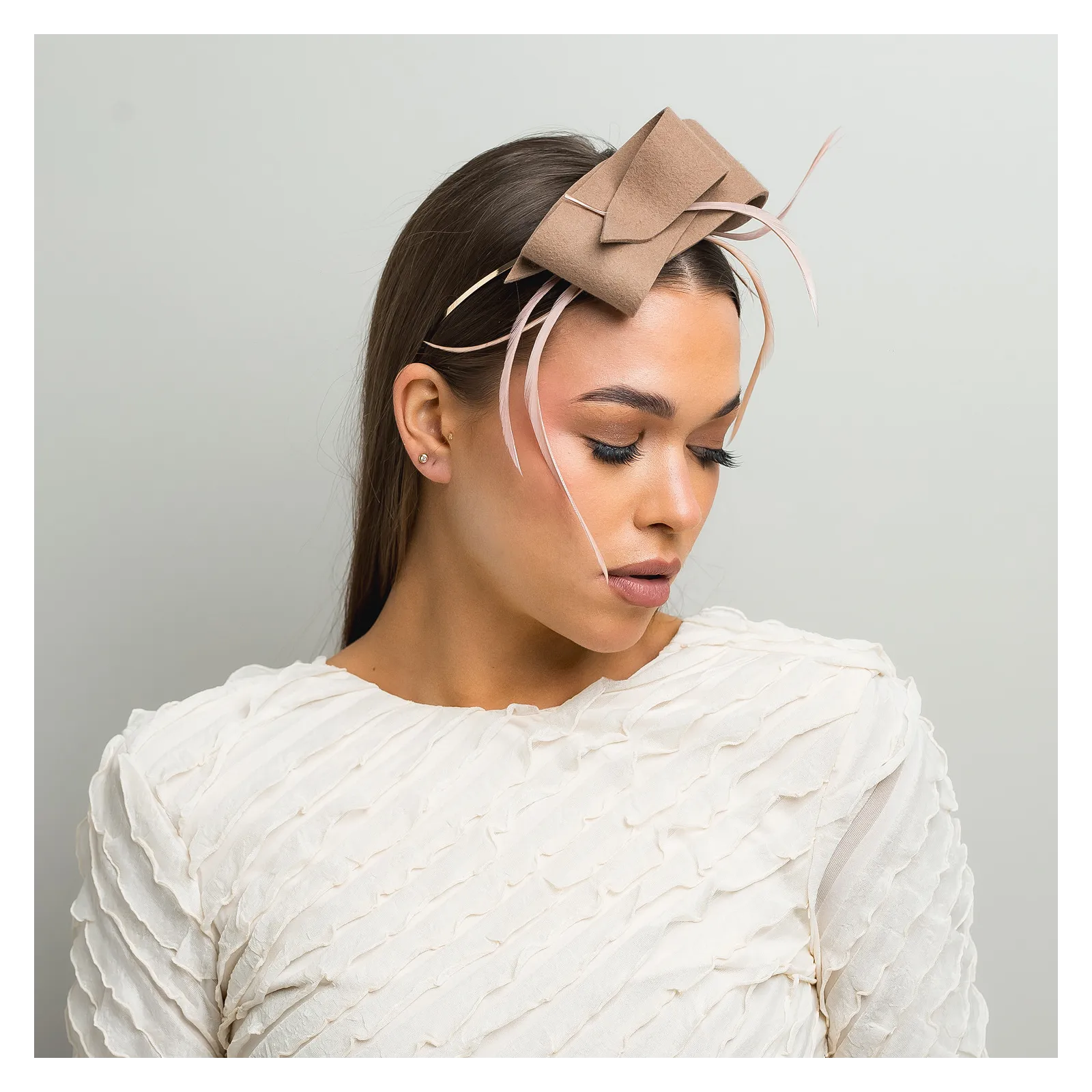 Beżowa ozdoba do włosów z piórkami.