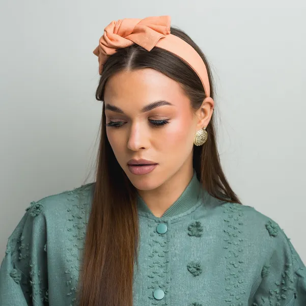 Brzoskwiniowa opaska z lnu z kokardką.