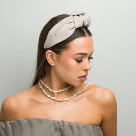 Sztywna opaska z beżowego naturalnego lnu z supłem.