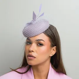 Liliowy kapelusik z piórkami i z woalką.