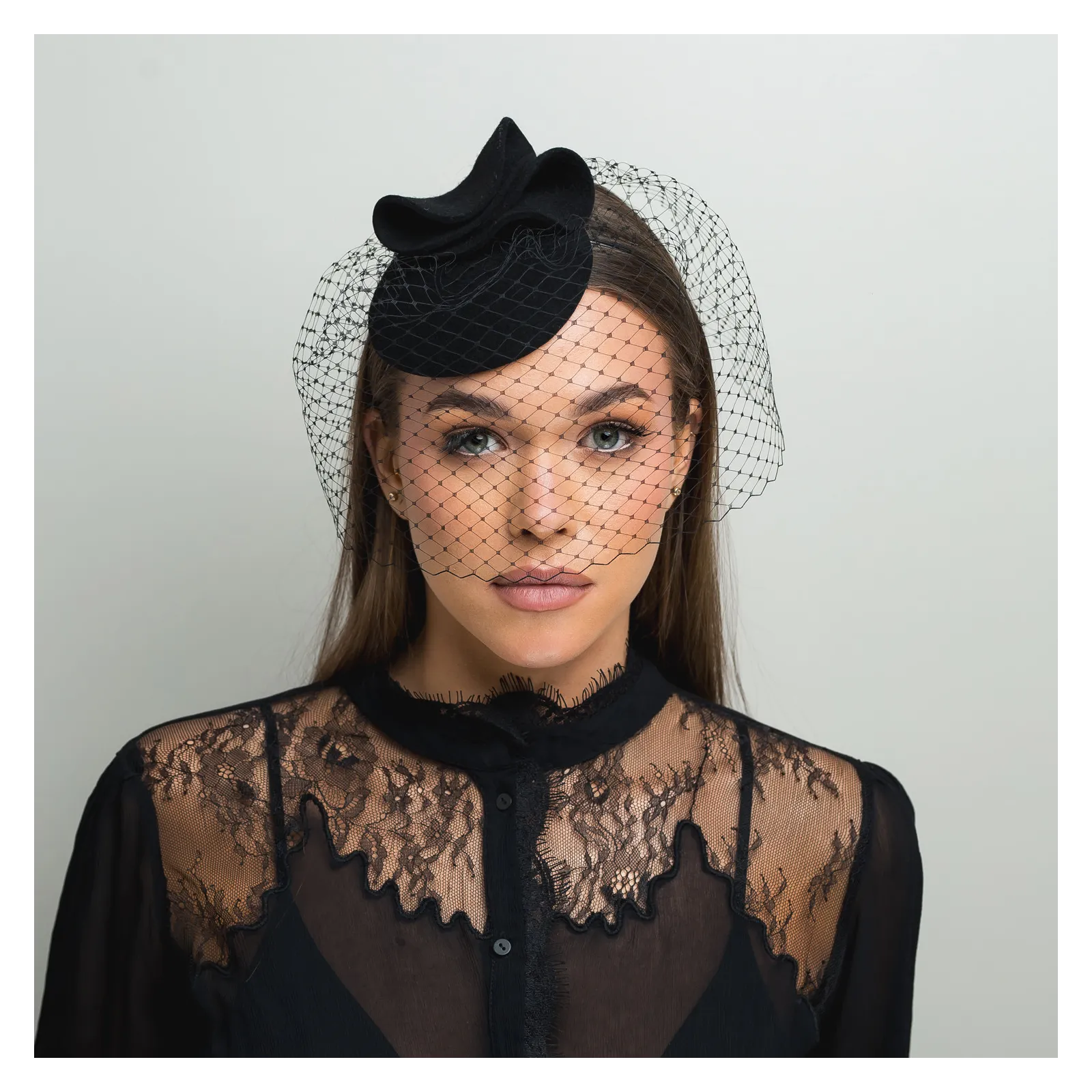 Czarne mini nakrycie głowy z woalką zakrywającą twarz.