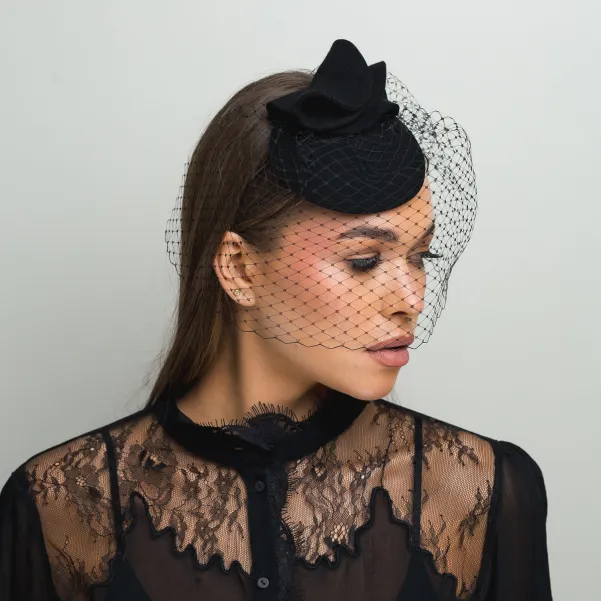 Czarne mini nakrycie głowy z woalką zakrywającą twarz.