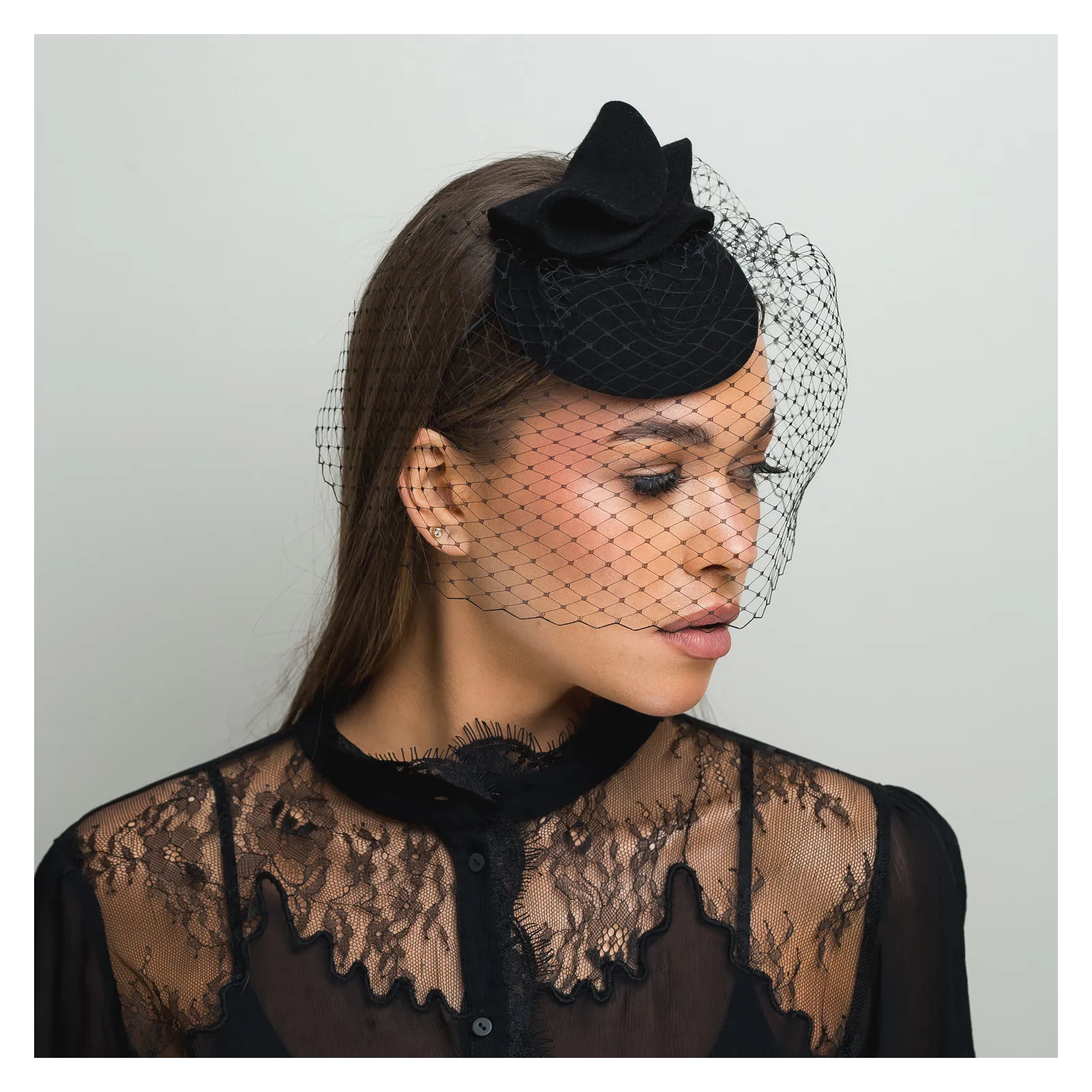 Czarne mini nakrycie głowy z woalką zakrywającą twarz.