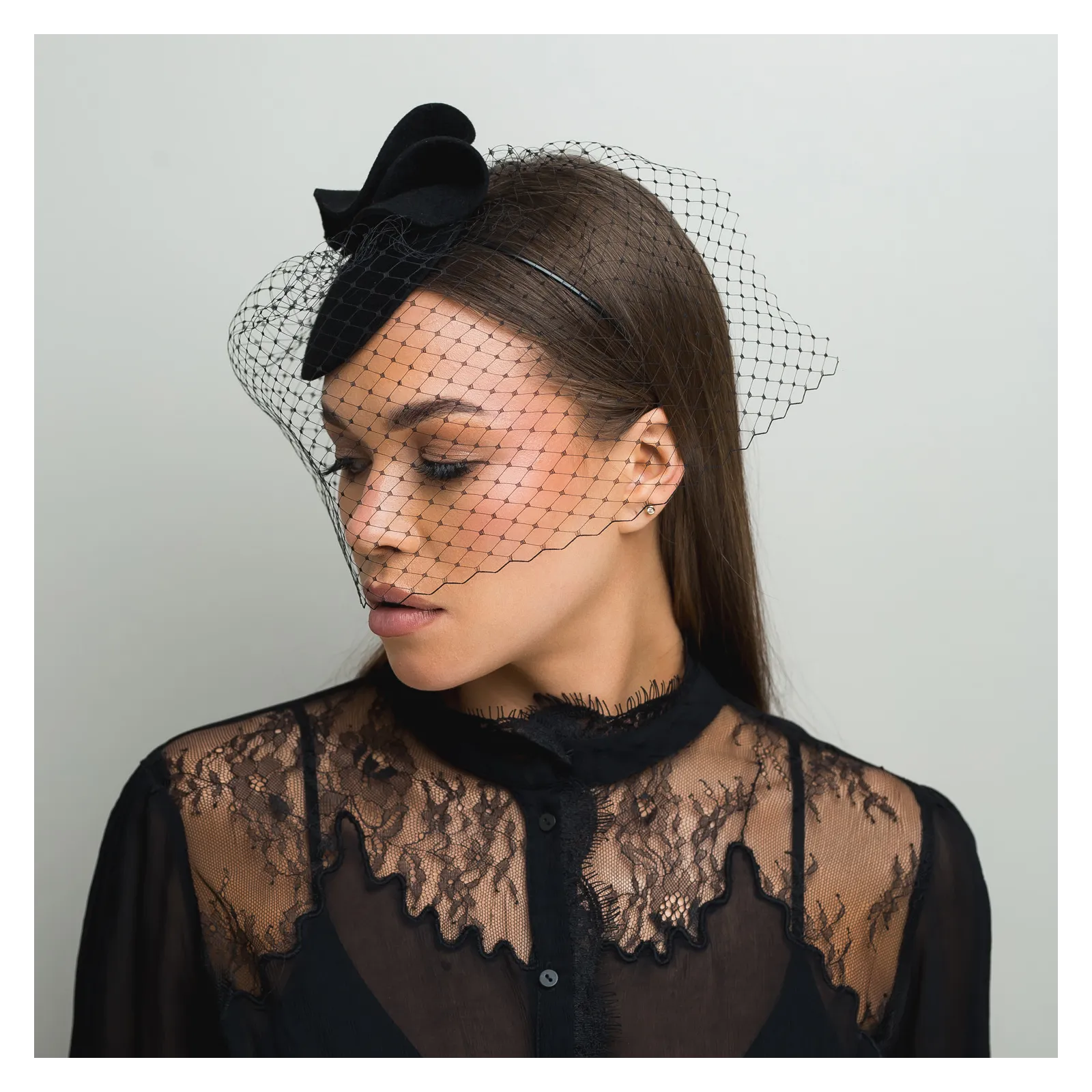 Czarne mini nakrycie głowy z woalką zakrywającą twarz.