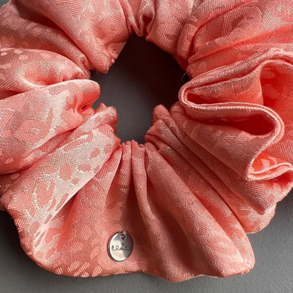 Duża jedwabista gumka do włosów brzoskwiniowa.