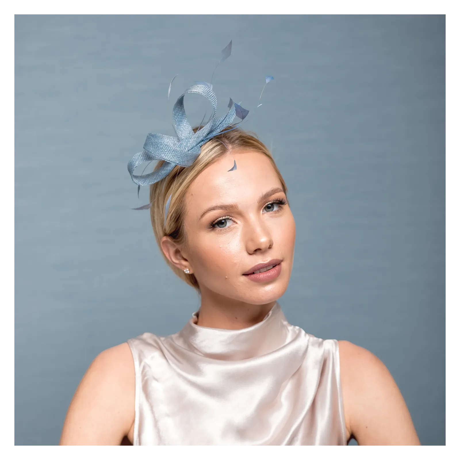 Subtelna niebieska ozdoba na głowę z piórkami.