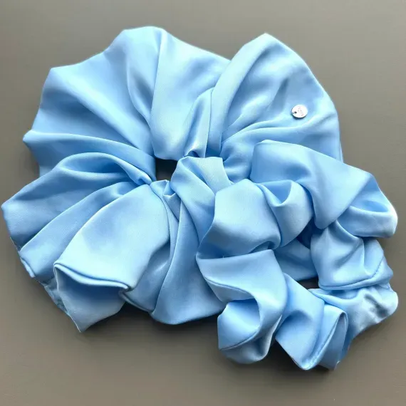 Duża, jedwabista gumka scrunchie w odcieniu błękitu.