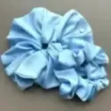 Duża, jedwabista gumka scrunchie w odcieniu błękitu.