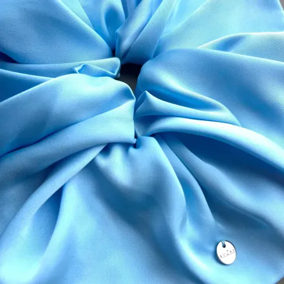 Mała, jedwabista gumka w odcieniu błękitu.