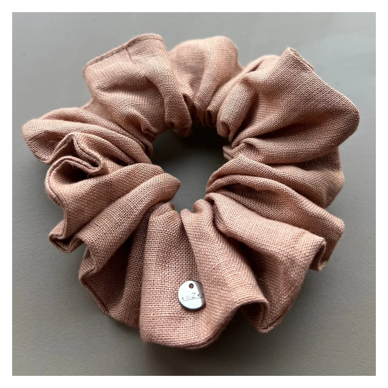 Materiałowa lniana gumka w odcieniu nude.