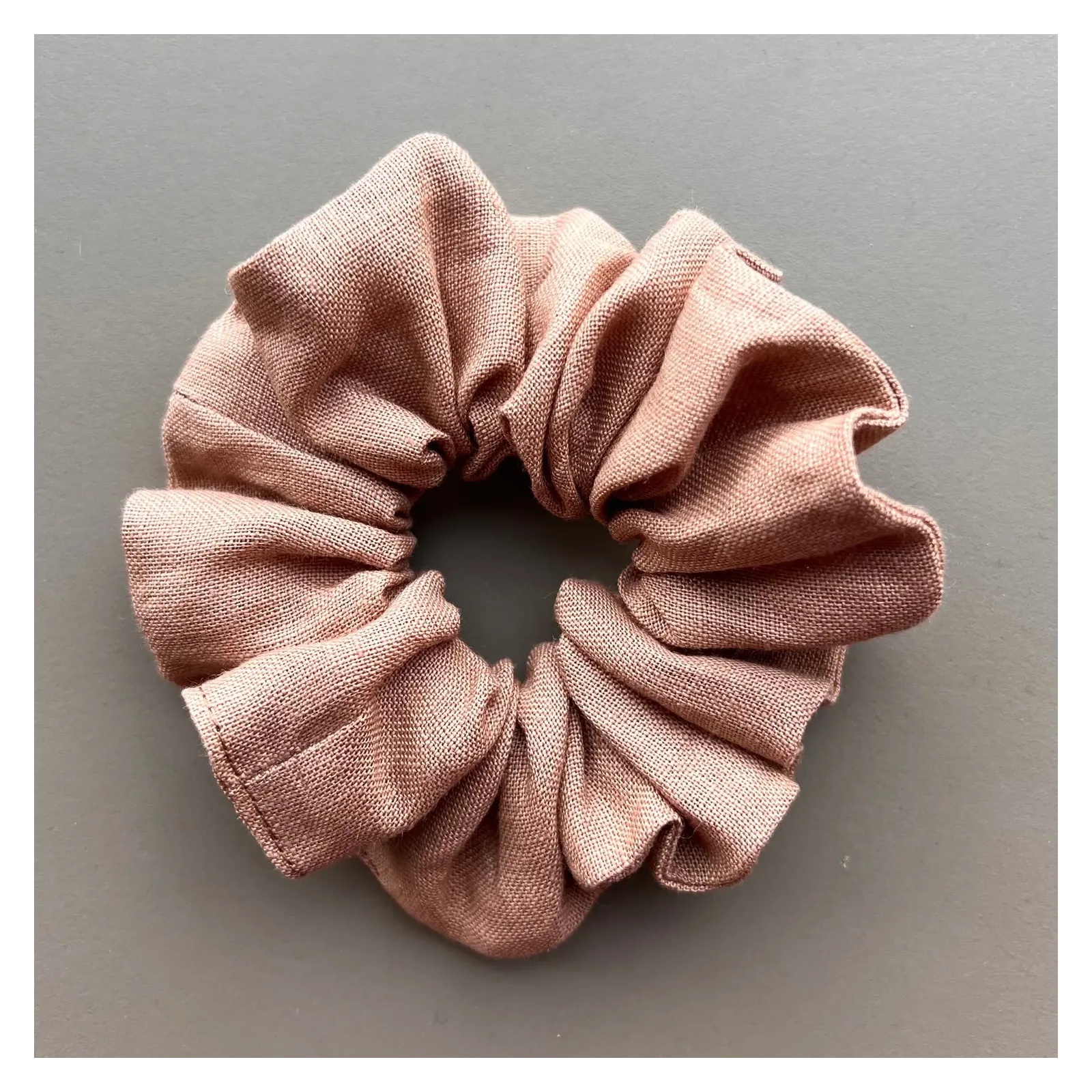 Materiałowa lniana gumka w odcieniu nude.