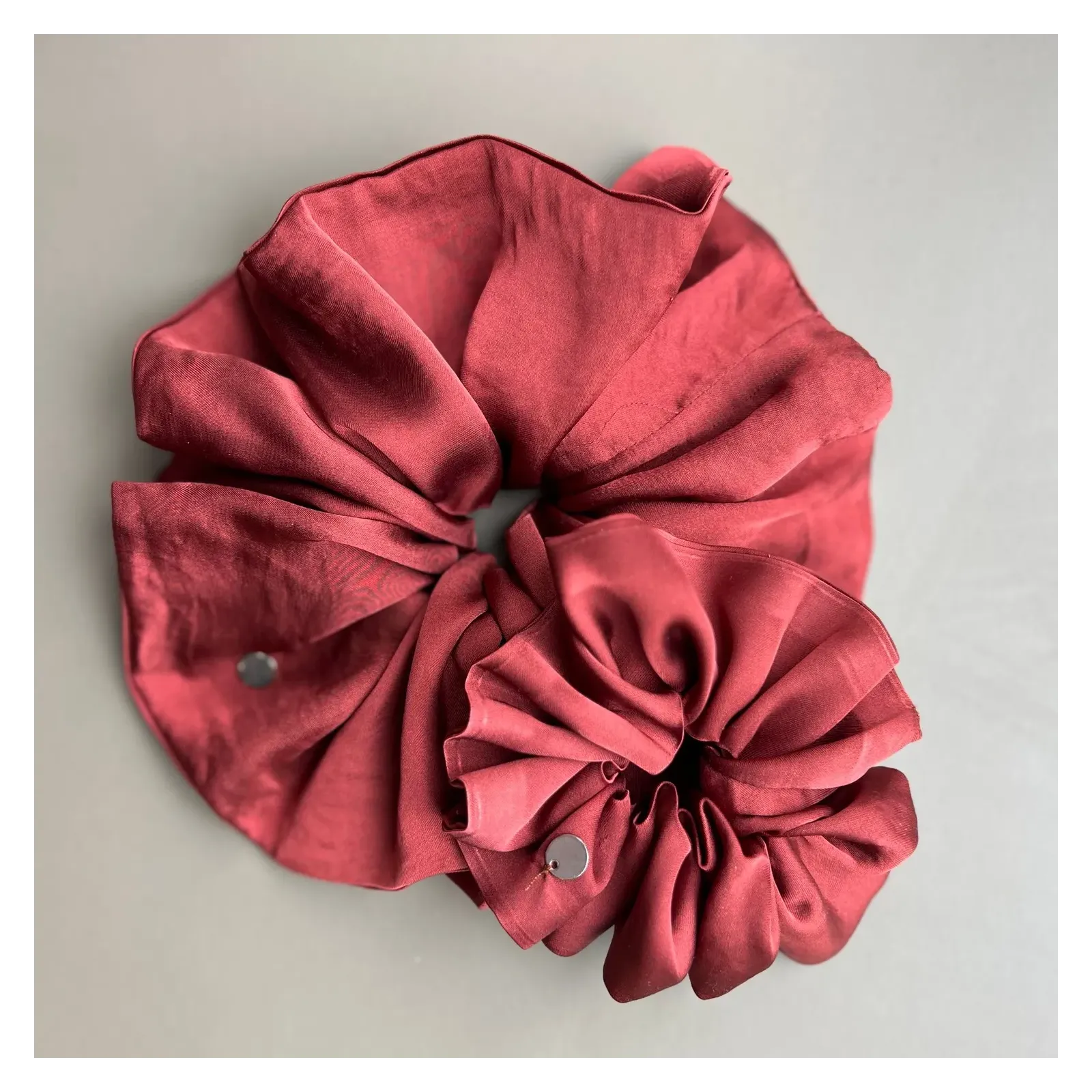 Duża, jedwabista gumka scrunchie w odcieniu bordo.
