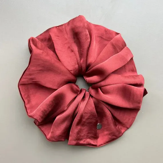 Duża, jedwabista gumka scrunchie w odcieniu bordo.