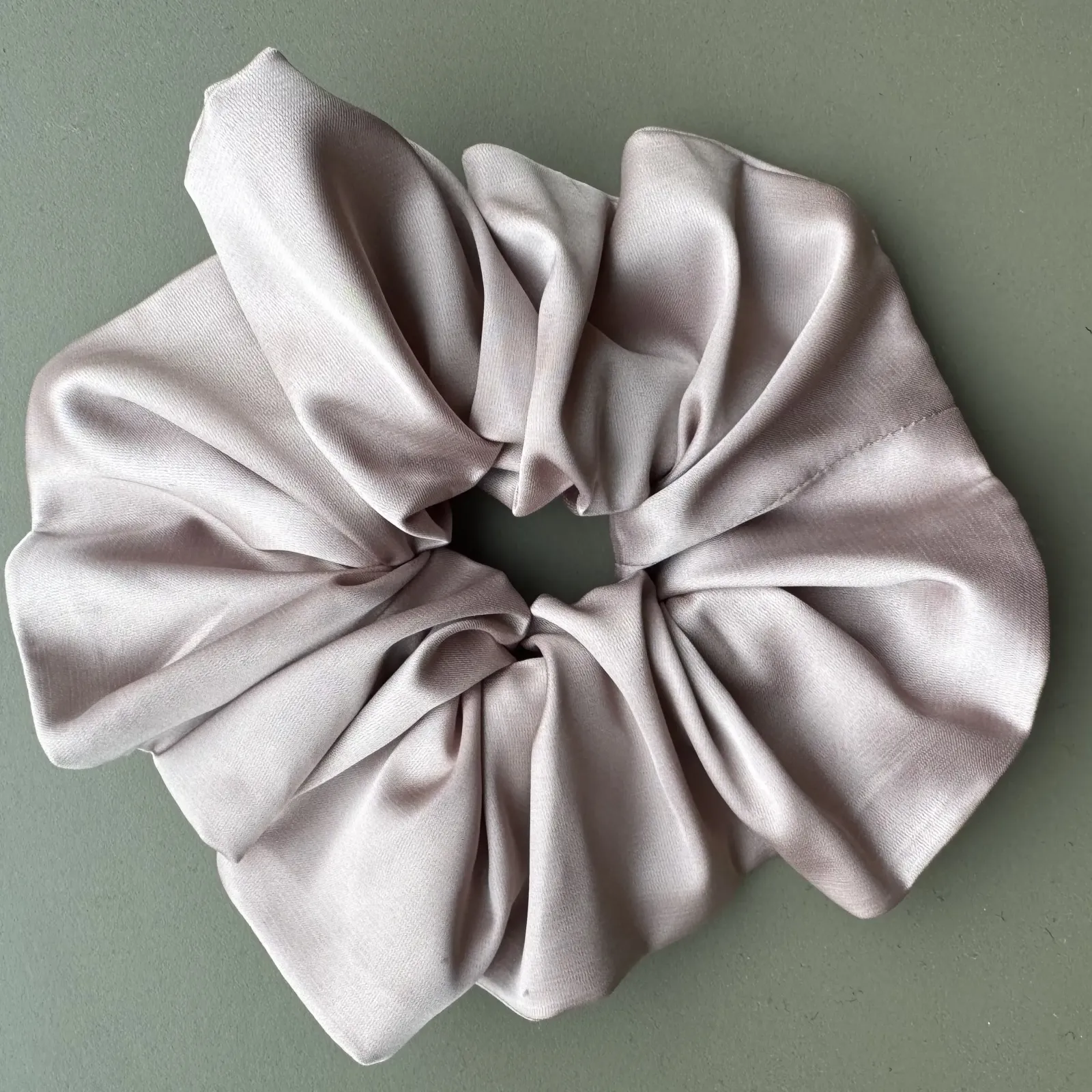 Duża, jedwabista gumka scrunchie w odcieniu pudrowy róż.