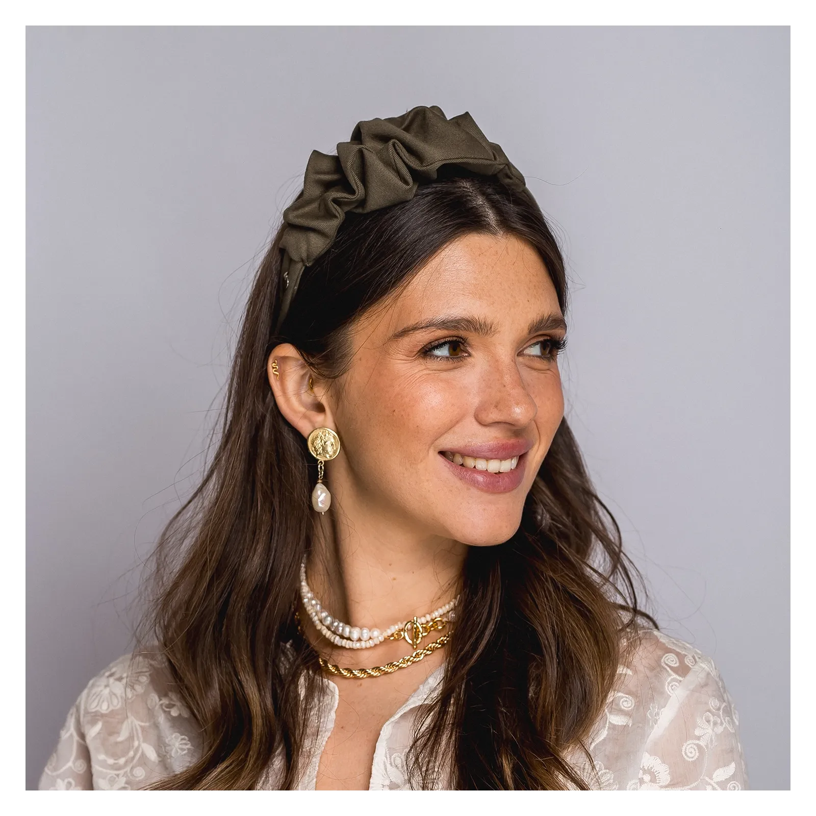 Opaska w odcieniu oliwkowej zieleni z delikatną ozdobą.