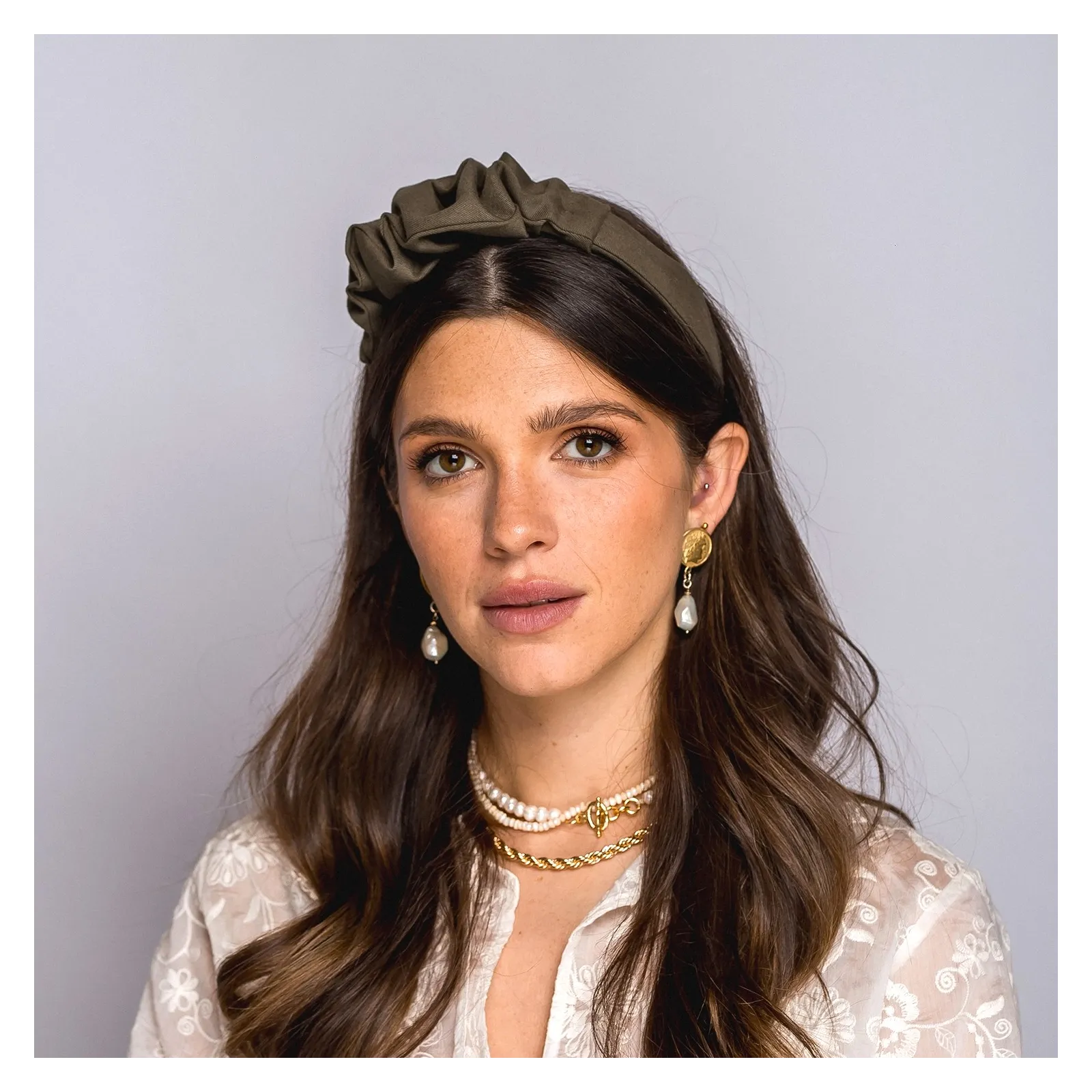 Opaska w odcieniu oliwkowej zieleni z delikatną ozdobą.