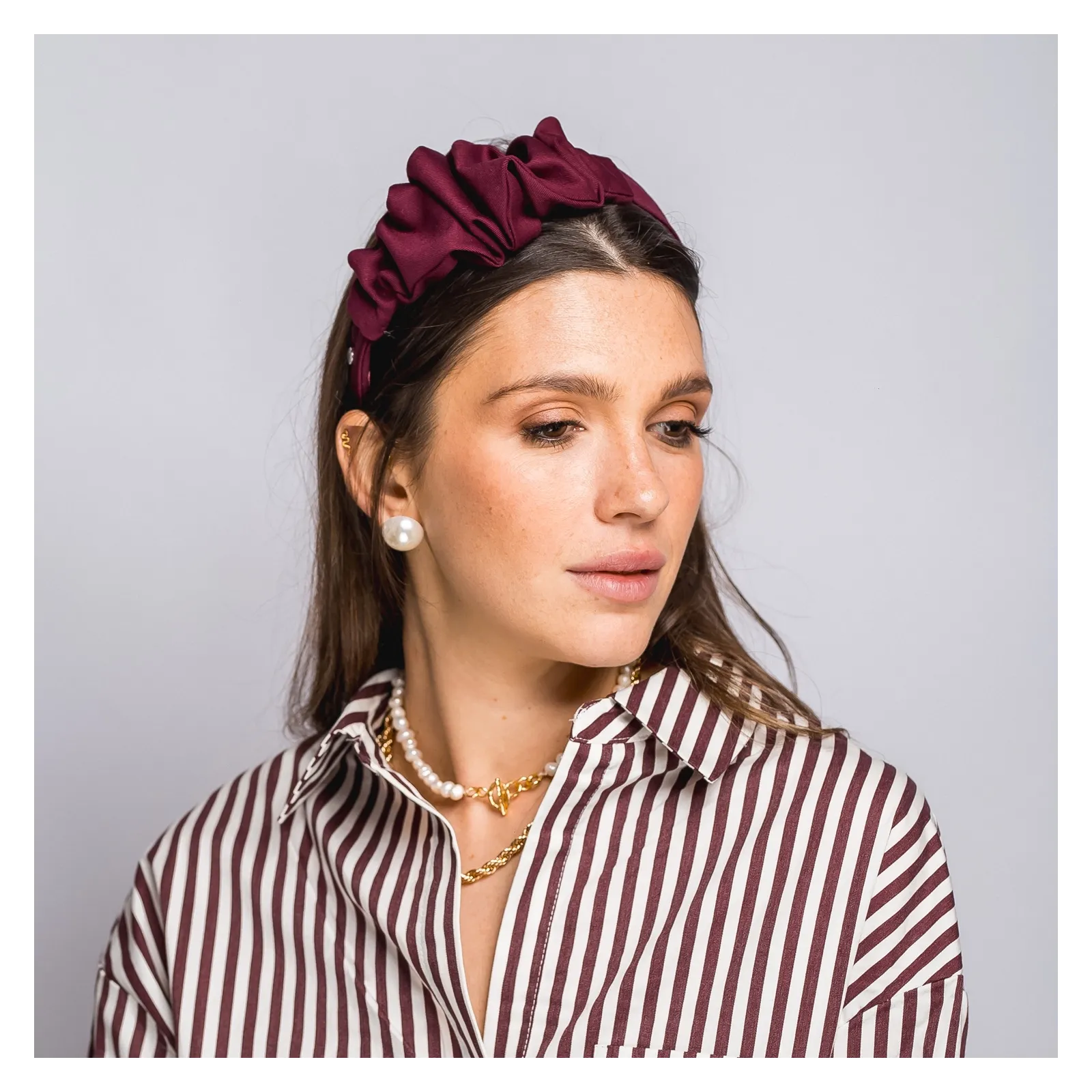 Bordowa opaska do włosów z niewielką ozdobą.