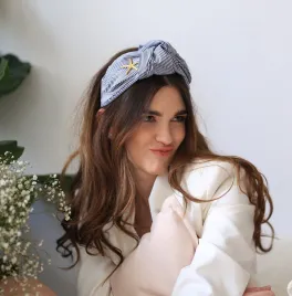 Sztywna wiązana opaska w paseczki ze złotym akcentem.