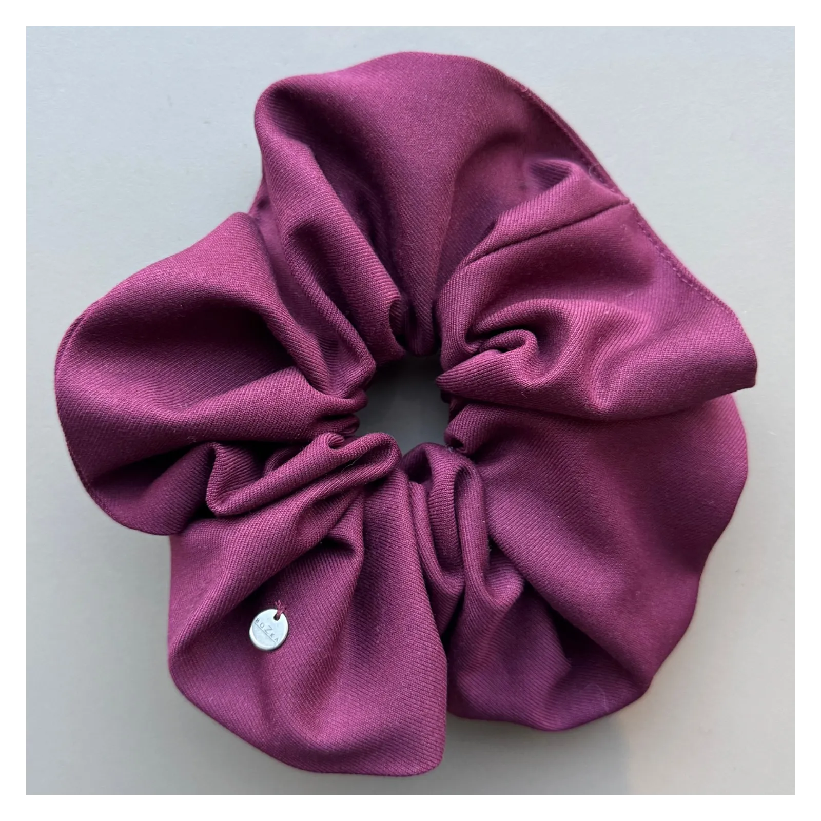 Duża burgundowa gumka do włosów.