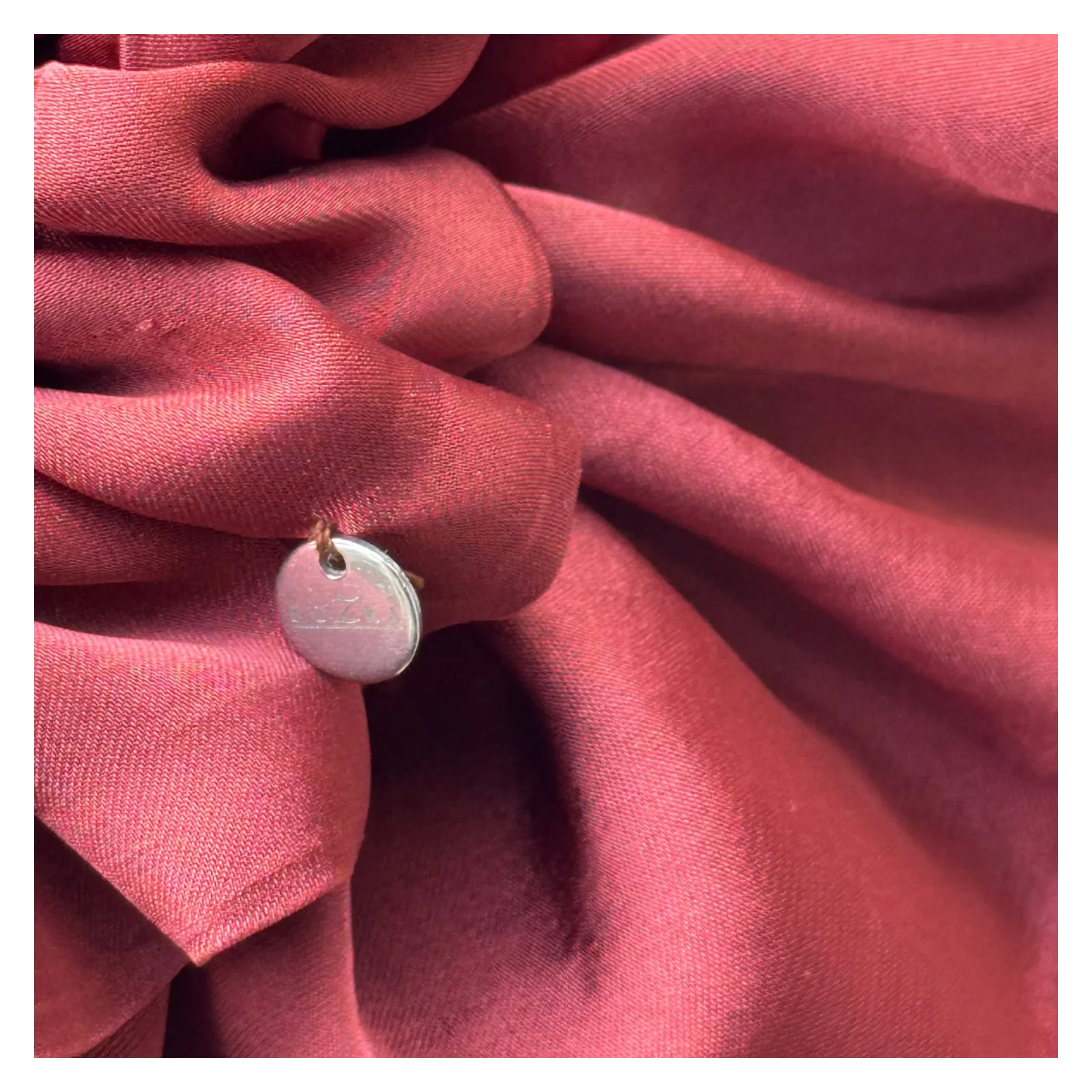 Duża, jedwabista gumka scrunchie w odcieniu bordo.