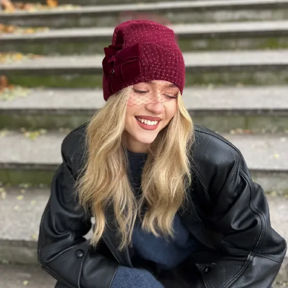 Burgundowa zdobiona czapka wełniana z woalką i kokardą.