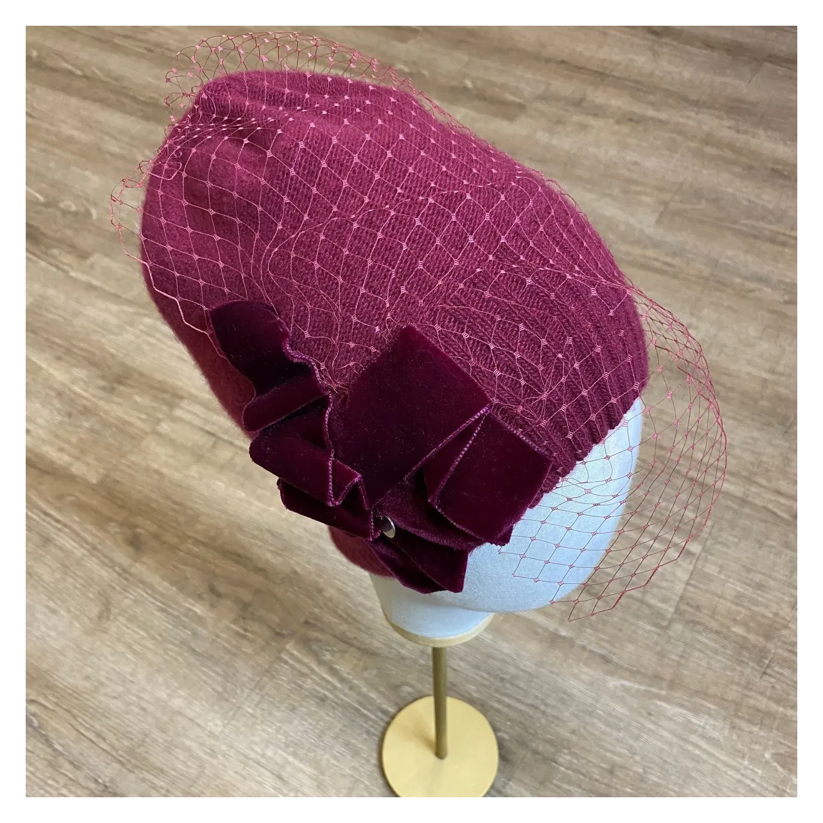Burgundowa zdobiona czapka wełniana z woalką i kokardą.