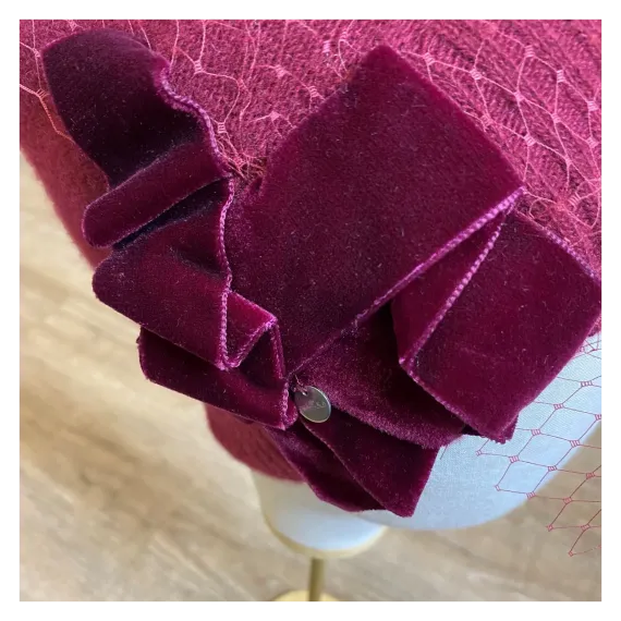 Burgundowa zdobiona czapka wełniana z woalką i kokardą.