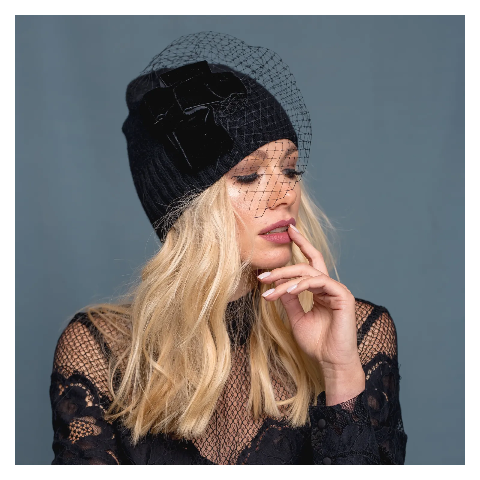 Czarna czapka merino z woalką i z kokardą.