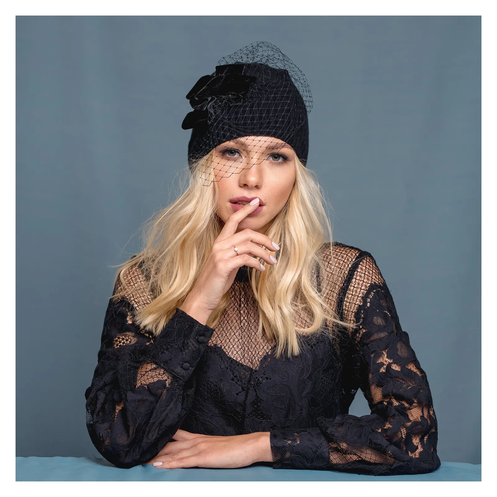 Czarna czapka merino z woalką i z kokardą.